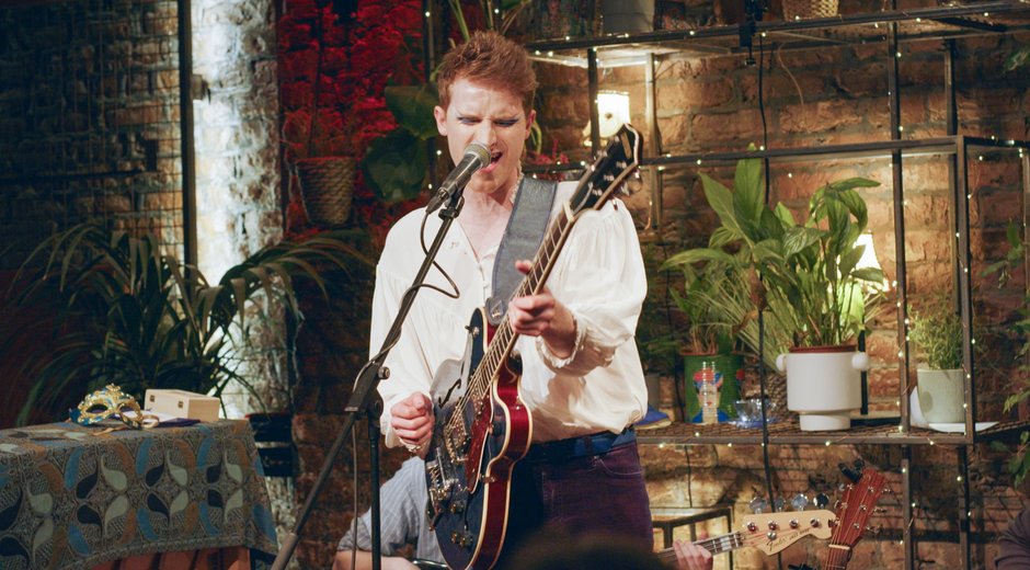 Bay Bryan performing with a guitar